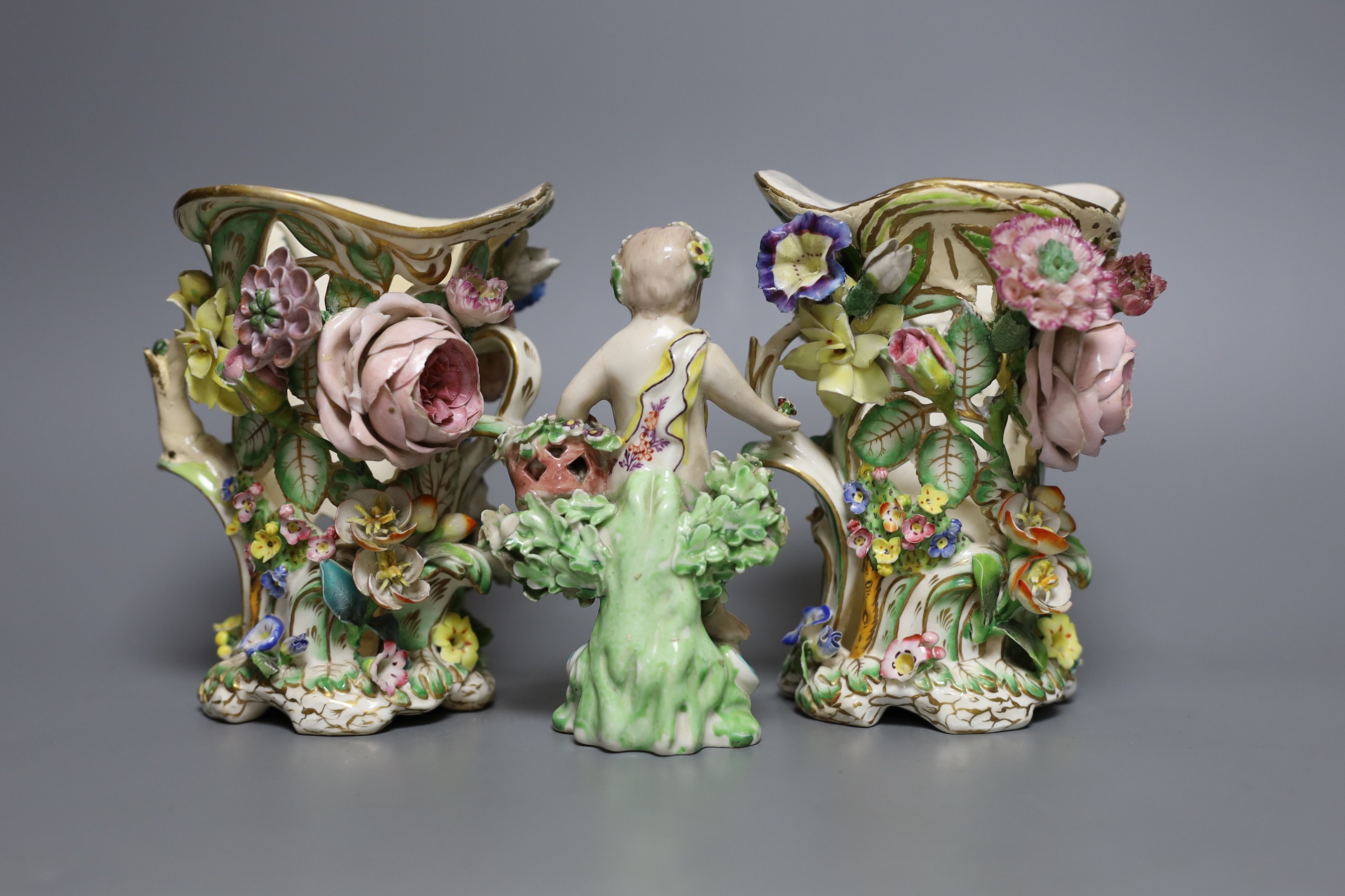 A 19th century Derby figure of a putti with flowers together with two floral encrusted porcelain vases, tallest 14cm